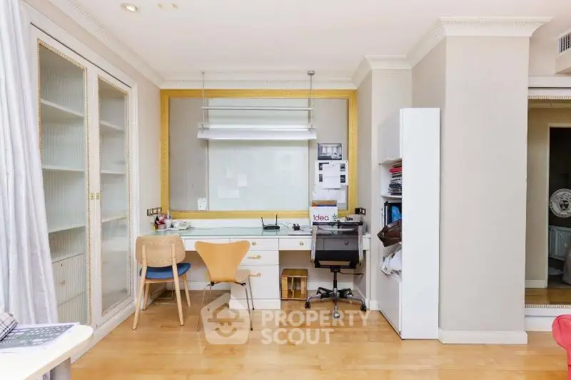 Spacious study room with modern furniture and ample storage in a stylish apartment.