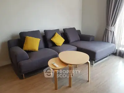 Modern living room with stylish gray sofa and yellow cushions, complemented by a sleek wooden coffee table.