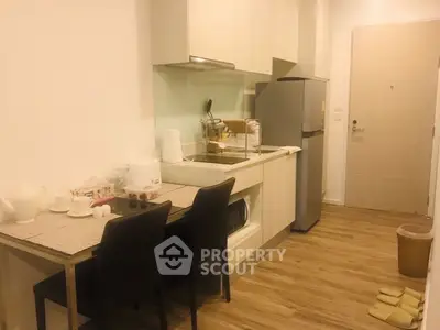 Modern kitchen with sleek cabinetry and dining area in cozy apartment