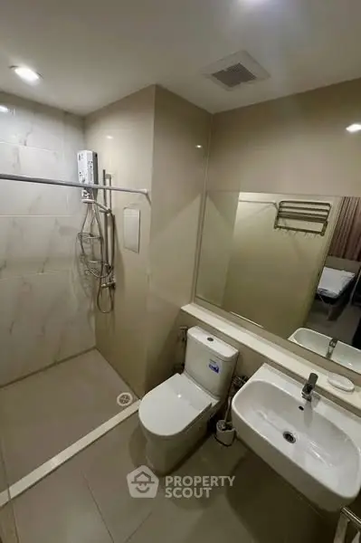 Modern bathroom with shower, toilet, and sink in a sleek design.