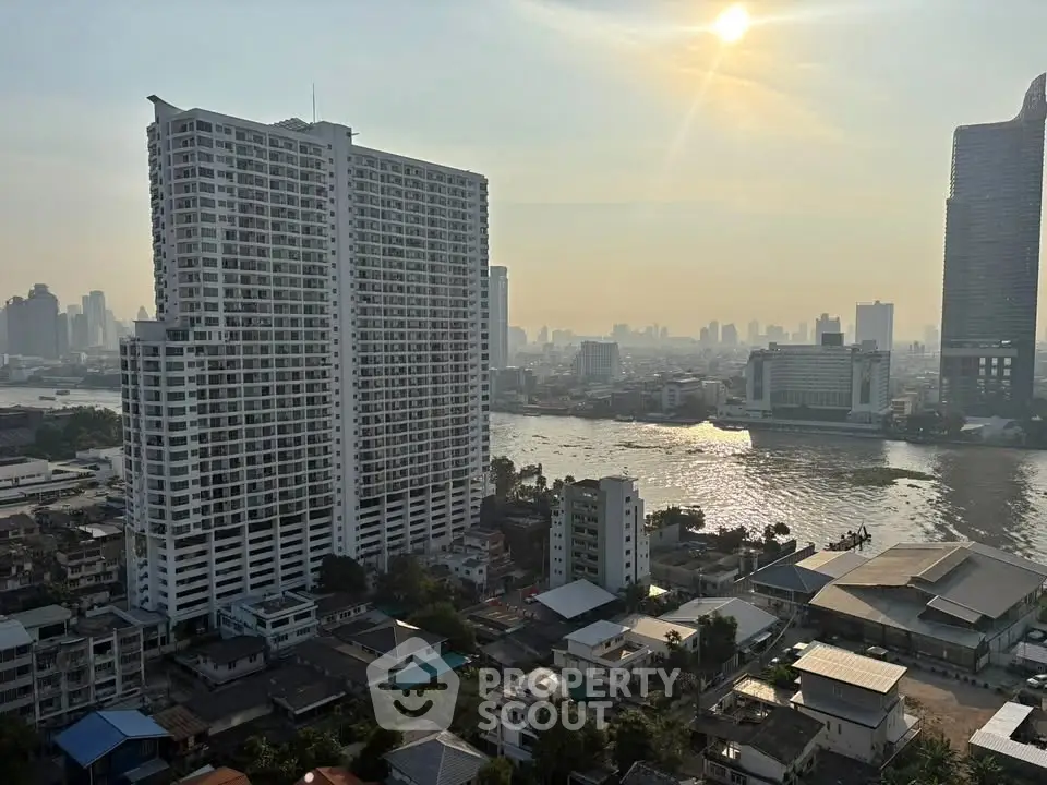 Stunning high-rise riverfront view with modern cityscape and serene sunset ambiance.