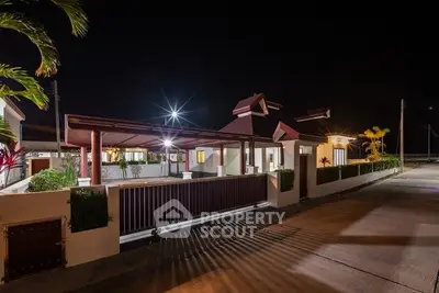 Modern house exterior at night with stylish lighting and landscaped garden.