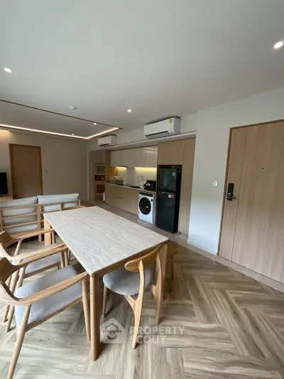 Modern open-plan living room with dining area and kitchen appliances