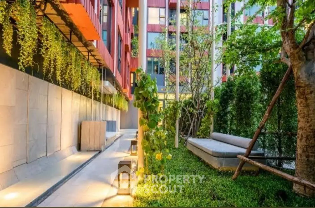 Modern building exterior with lush garden and ambient lighting