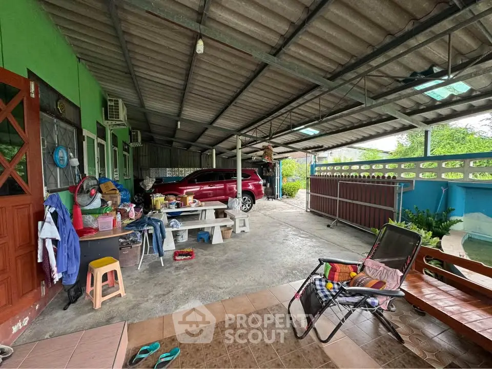 Spacious covered patio with seating and parking area in a residential home.