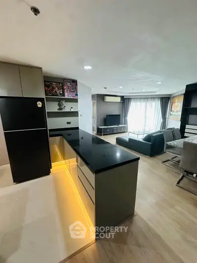 Modern open-layout kitchen and living room with sleek design and ambient lighting