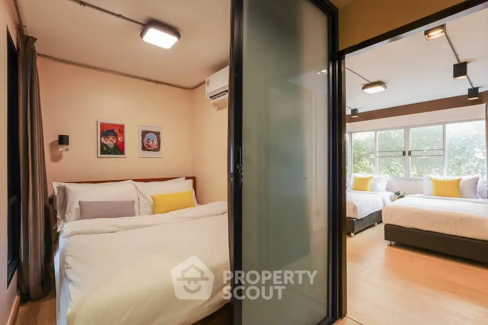Modern bedroom with large windows and cozy decor, perfect for relaxation.