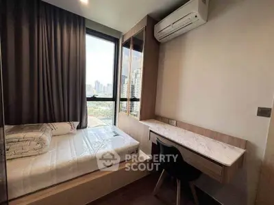 Modern bedroom with city view, featuring a cozy bed and sleek study desk under air conditioning.