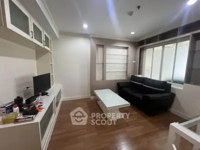 Modern living room with sleek furniture and built-in storage in a cozy apartment.