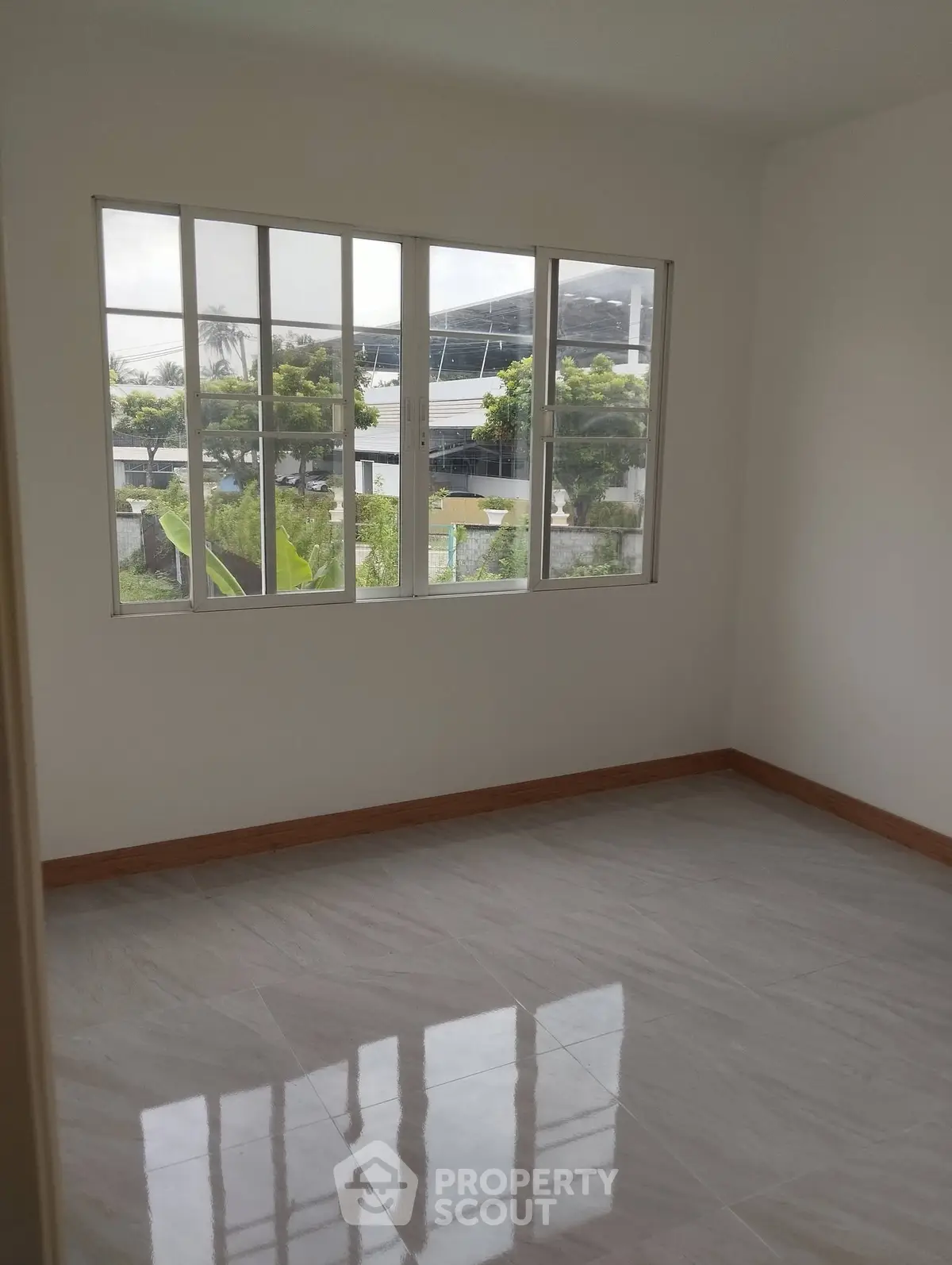 Bright empty room with large window and glossy tiled floor, perfect for customization.