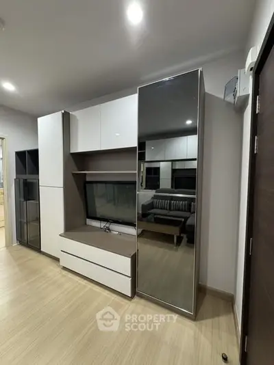 Modern living room with sleek furniture and built-in storage solutions.