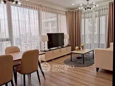 Modern living room with large windows and stylish decor in high-rise apartment.