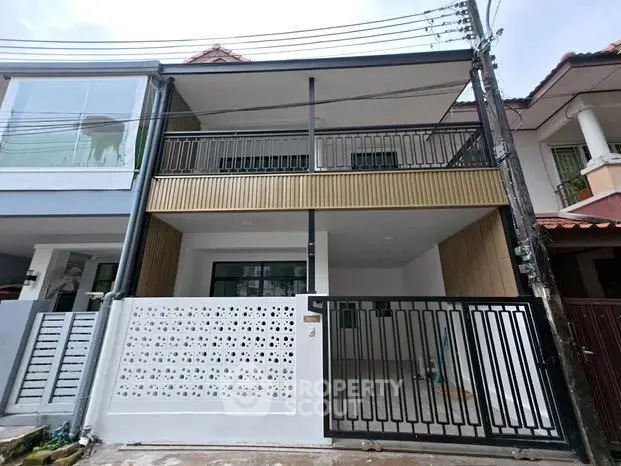 Modern two-story townhouse with stylish facade and gated entrance