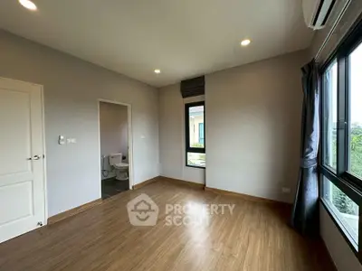 Spacious unfurnished room with large windows and en-suite bathroom, perfect for customization.