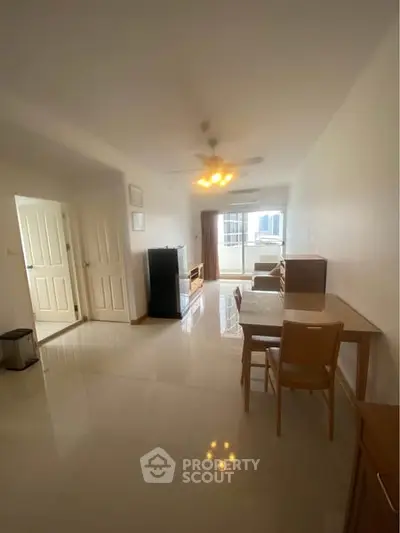 Spacious living room with dining area and city view balcony in modern apartment.