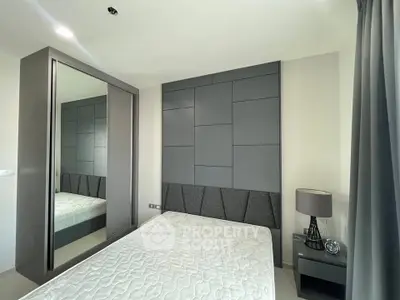 Modern bedroom with stylish grey paneling and mirrored wardrobe