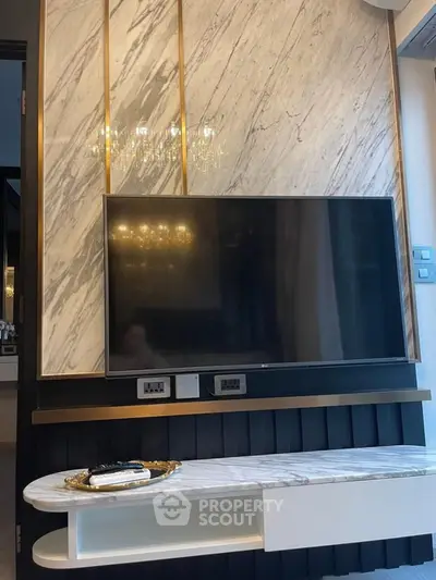 Luxurious living room with marble accent wall and mounted TV, featuring elegant lighting and modern design.