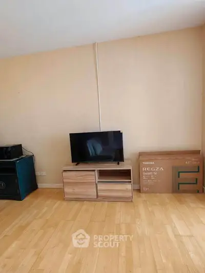 Spacious living room with wooden flooring and modern TV setup