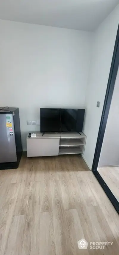 Modern living room with sleek TV setup and wooden flooring