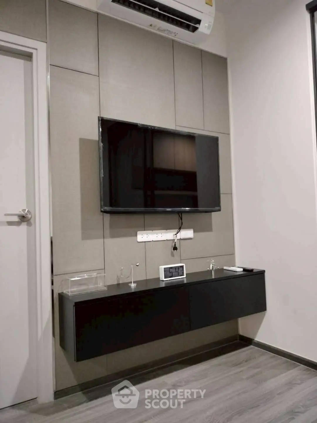 Modern living room with wall-mounted TV and sleek storage unit.