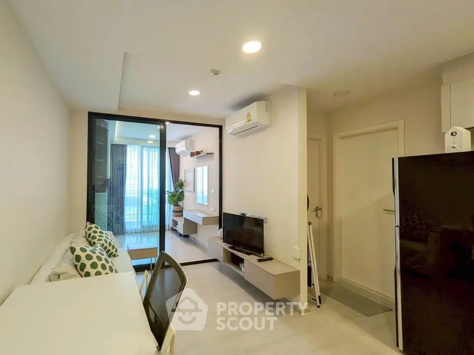 Modern living room with sleek design and natural light, featuring a cozy seating area and contemporary decor.