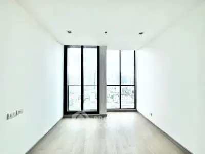 Spacious empty room with large windows offering stunning city views, perfect for customization.