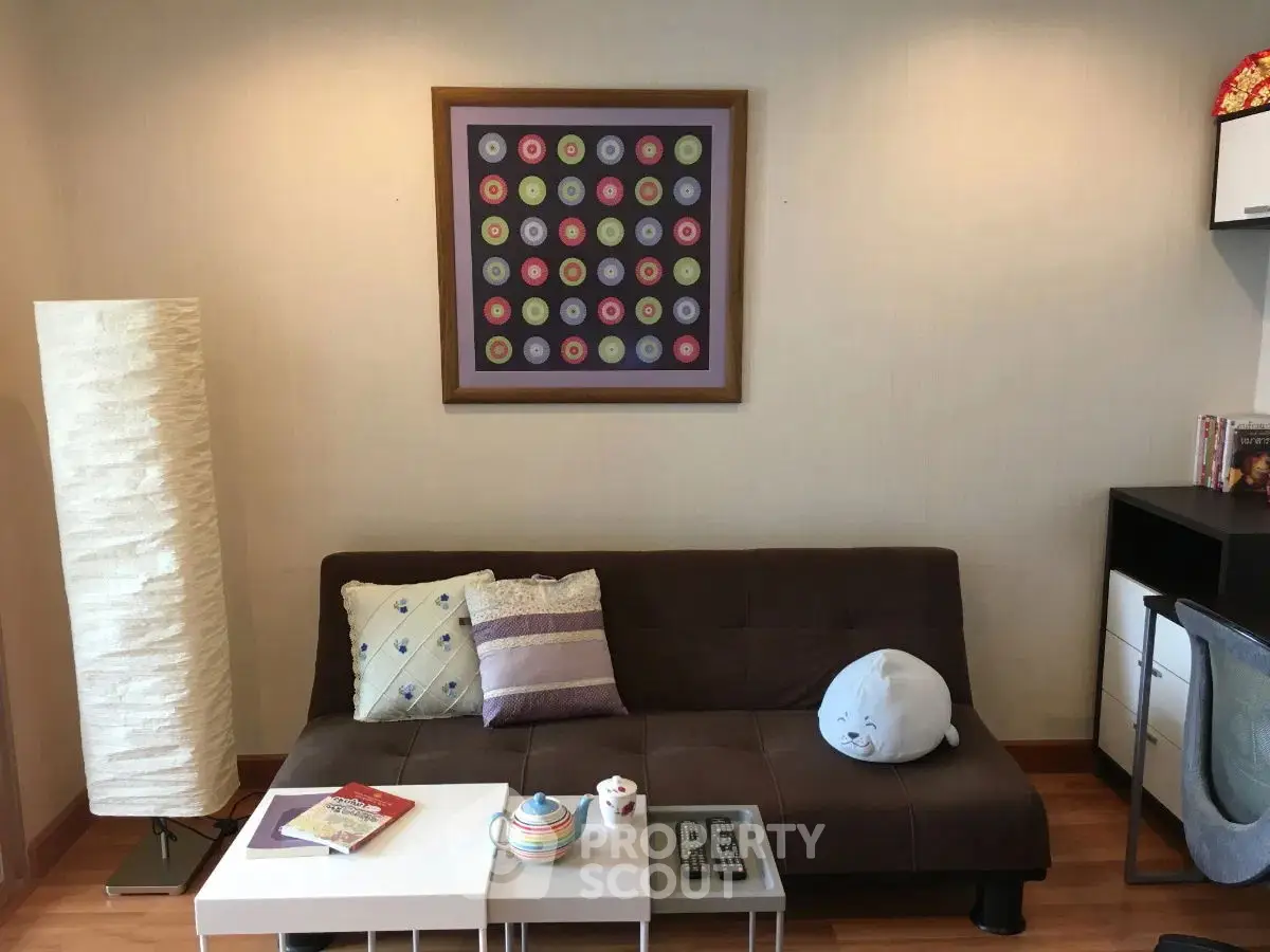 Cozy living room with modern decor, featuring a stylish sofa, unique artwork, and ambient lighting.