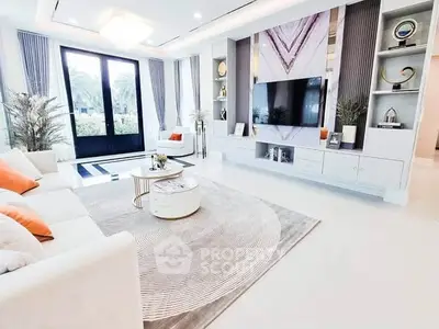Luxurious modern living room with elegant decor and large TV, featuring stylish furniture and a serene view.