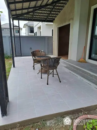 Charming patio with wicker chairs and tiled flooring in modern home exterior