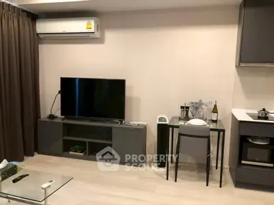 Modern living room with sleek furniture and air conditioning, featuring a TV and dining area.