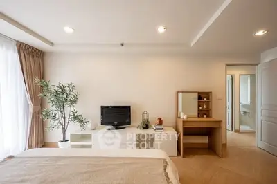 Spacious bedroom with modern decor and natural light, featuring a cozy bed and stylish furniture.