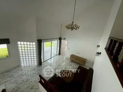 Spacious living room with high ceiling and elegant chandelier