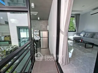 Modern apartment with sleek kitchen and cozy living room, featuring large windows and stylish decor.