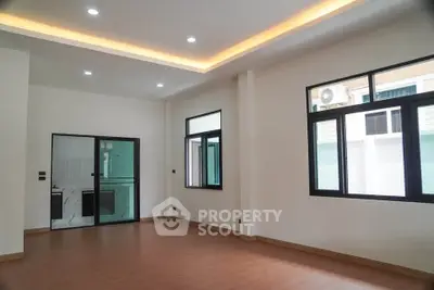 Spacious modern living room with large windows and wooden flooring