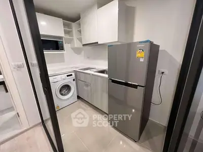 Modern kitchen with washing machine and fridge in compact layout