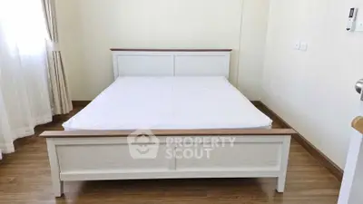 Spacious bedroom with elegant wooden bed frame and natural light