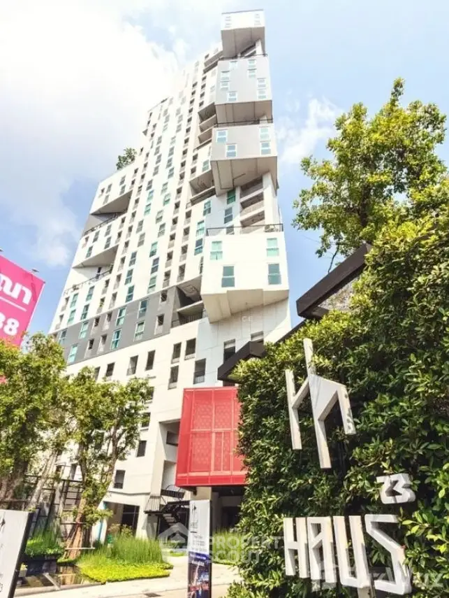 Modern high-rise building with unique architecture and lush greenery in urban setting.