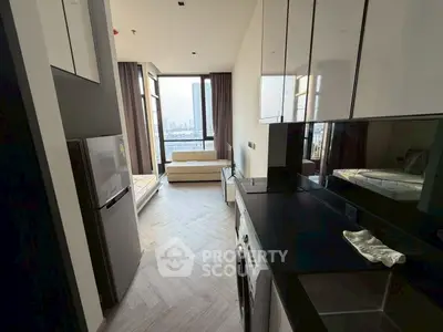 Modern apartment with sleek kitchen and stunning city view from the living area.