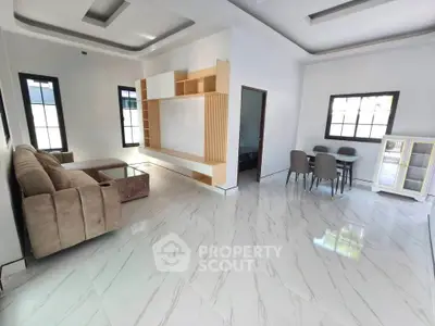 Spacious modern living room with elegant tile flooring and stylish furniture.