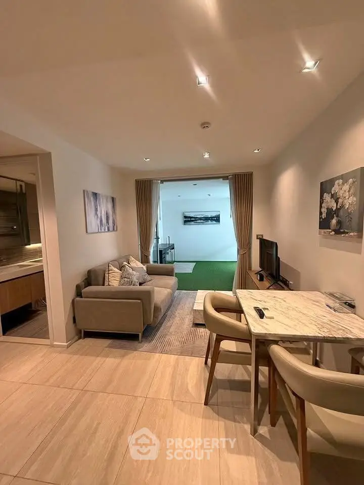 Modern living room with elegant decor and open view to a green space, featuring cozy seating and dining area.
