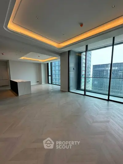 Spacious modern living room with floor-to-ceiling windows and elegant lighting in a luxury apartment.