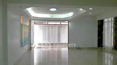 Spacious living room with modern ceiling design and large windows for natural light.