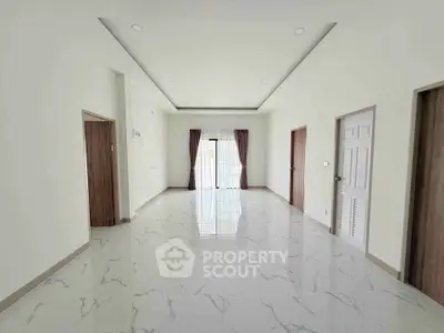 Spacious modern living room with marble flooring and large windows for natural light.