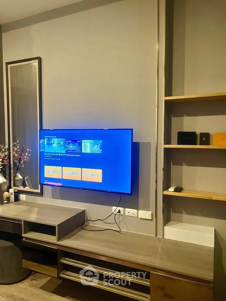 Modern living room with wall-mounted TV and stylish shelving