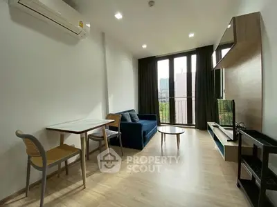Modern living room with balcony view, featuring sleek furniture and natural light.