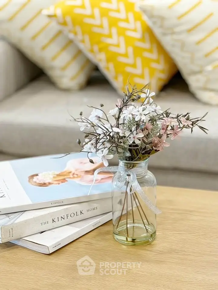 Chic living room with stylish decor, featuring a cozy sofa and elegant floral arrangement on a wooden table.