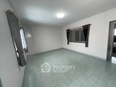 Spacious empty room with tiled floor and large windows, perfect for customization.
