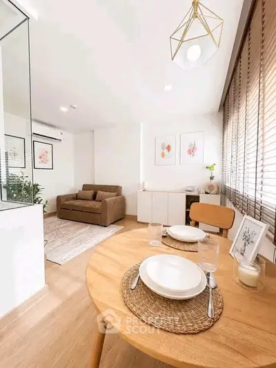 Modern living room with stylish dining area, featuring elegant decor and natural light through large windows.