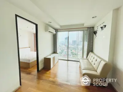 Modern apartment with city view, featuring hardwood floors and a cozy living area with natural light.