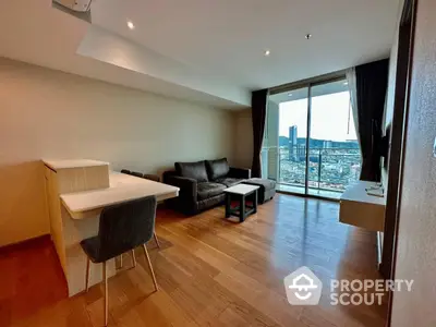 Spacious living room with modern furniture, large windows offering panoramic city views, and hardwood flooring, in a high-rise apartment.